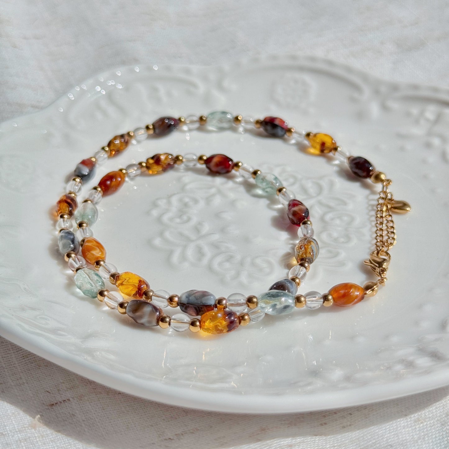 Multicolored beaded necklace on a white textured surface