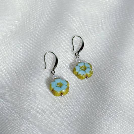 Pearl drop earrings with blue Czech glass floral charms, minimalist lightweight handmade jewelry on a soft fabric background