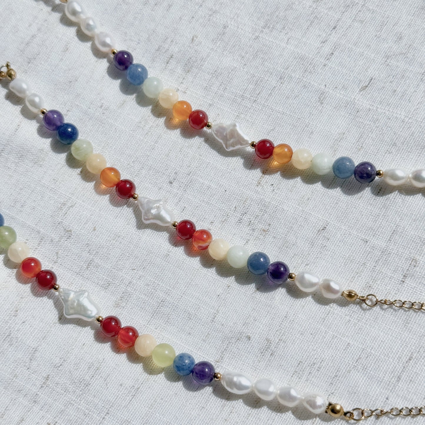 Bracelets with multicolored natural stone beads on a textured white background