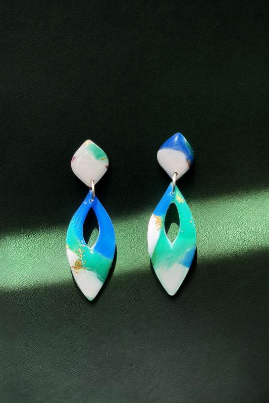 Handmade earrings with marble-like pattern in blue, green, and white, accented with gold leaf, evoking the colors of the aurora in the night sky.