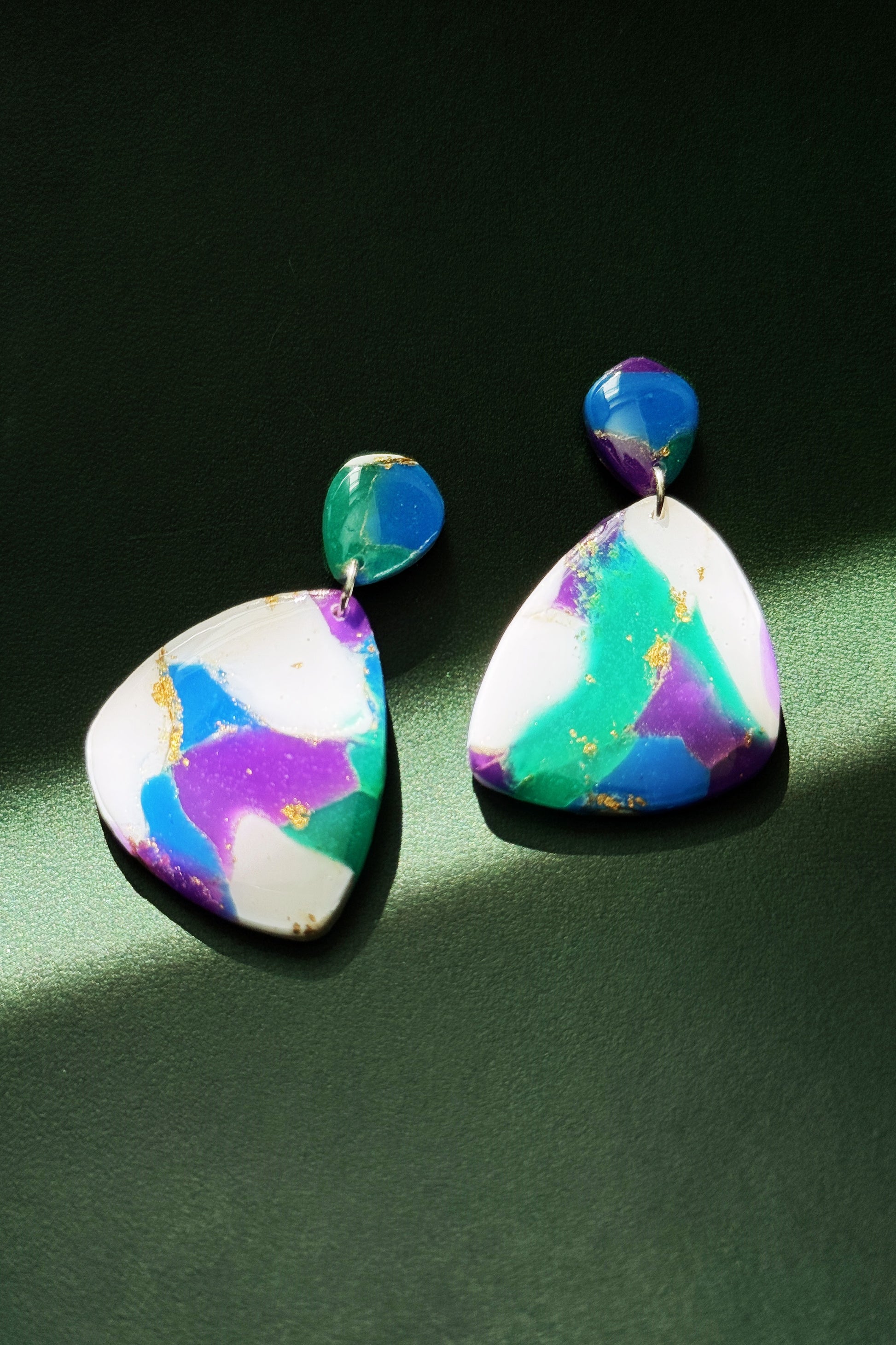 Handmade earrings with marble-like pattern in blue, green, purple, and white, accented with gold leaf, evoking the colors of the aurora in the night sky.
