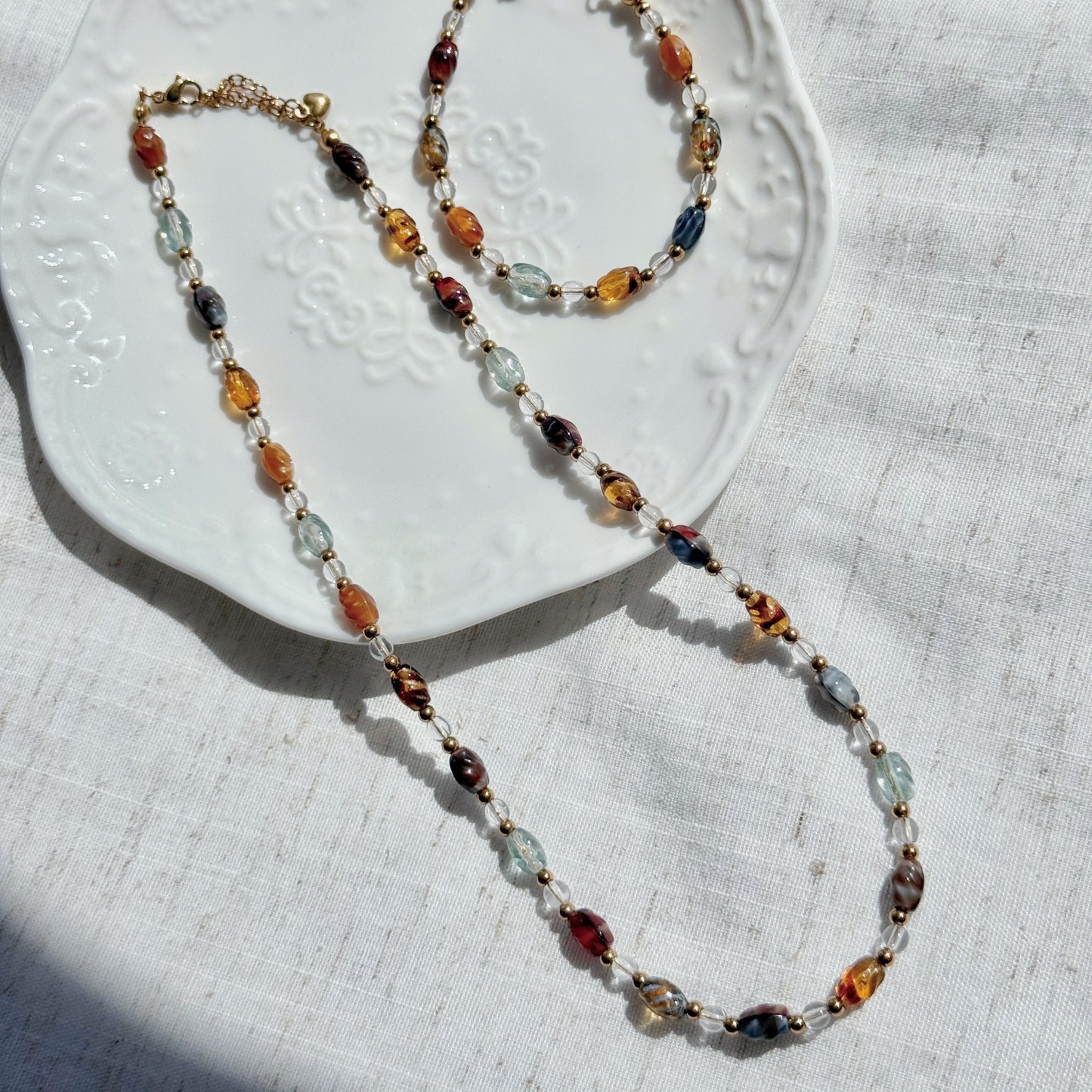 Multicolored beaded necklace on a textured white surface