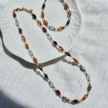 Multicolored beaded necklace on a textured white surface
