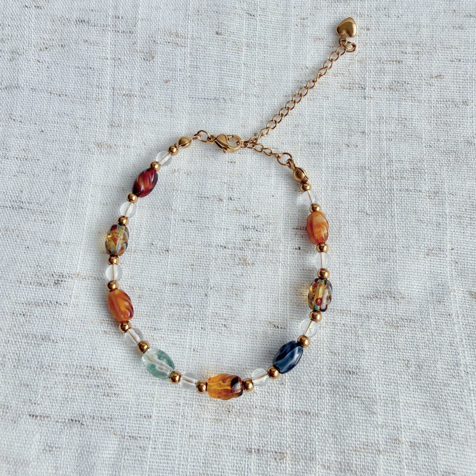 Beaded bracelet with multicolored beads on a textured fabric background