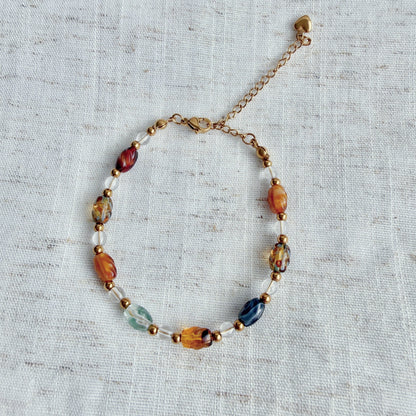 Beaded bracelet with multicolored beads on a textured fabric background