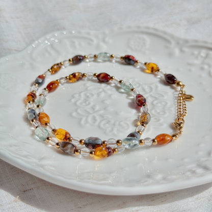 Multicolored beaded necklace on a white textured surface