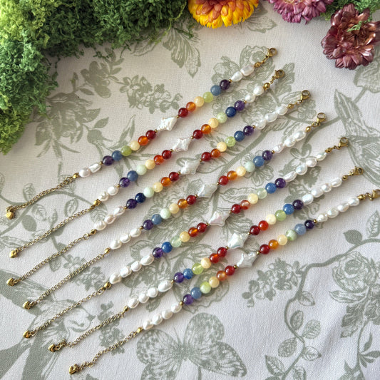 Set of colorful beaded bracelets on a floral fabric background with flowers.