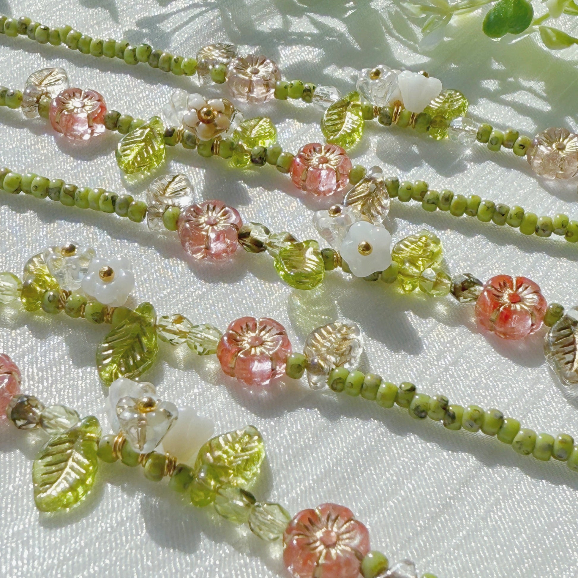 handmade czech glass beaded bracelet with green seed beads pink flower beads and translucent leaf charms botanical jewelry