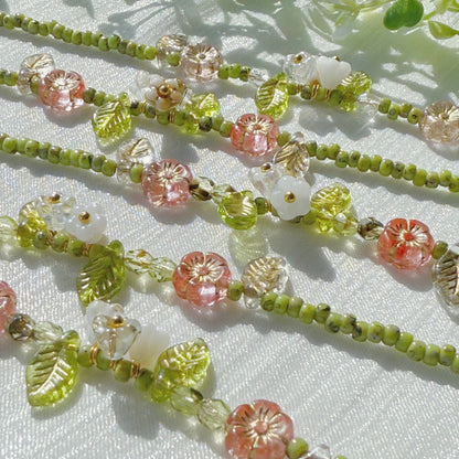 handmade czech glass beaded bracelet with green seed beads pink flower beads and translucent leaf charms botanical jewelry