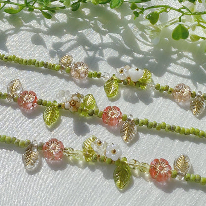handmade czech glass beaded bracelet with green seed beads pink flower beads and translucent leaf charms botanical jewelry