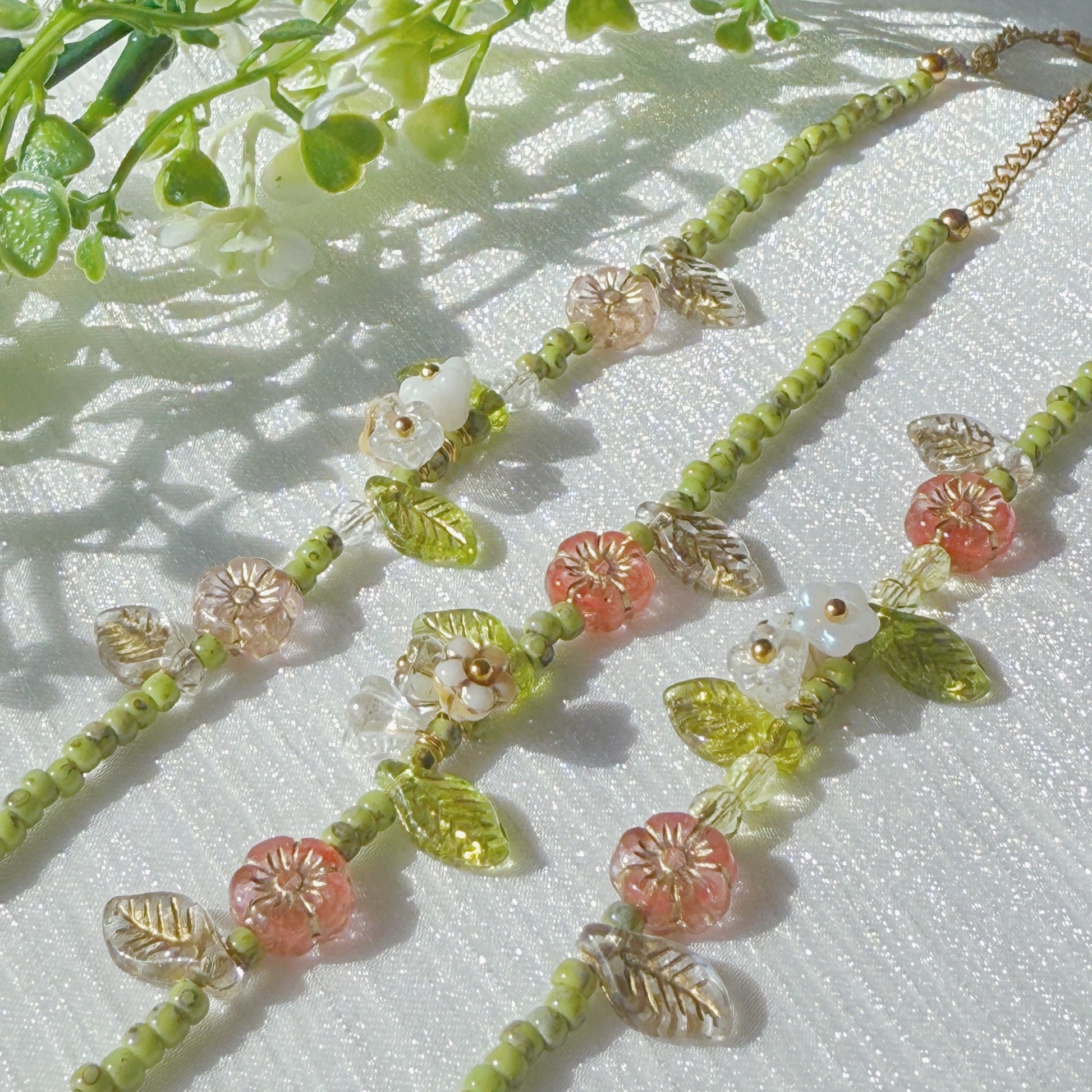 handmade czech glass beaded bracelet with green seed beads pink flower beads and translucent leaf charms botanical jewelry