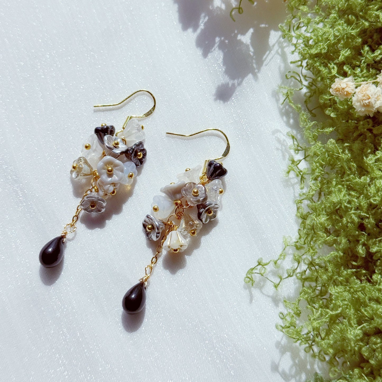 Handmade Czech glass flower cluster earrings in black, white, and neutral tones, featuring layered floral beads and a dark teardrop drop, soft contrast with a moody, elegant feel.