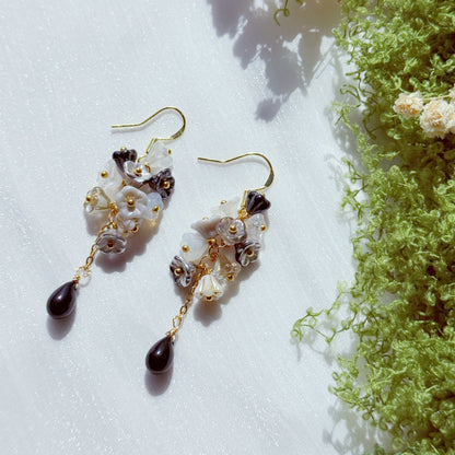 Handmade Czech glass flower cluster earrings in black, white, and neutral tones, featuring layered floral beads and a dark teardrop drop, soft contrast with a moody, elegant feel.
