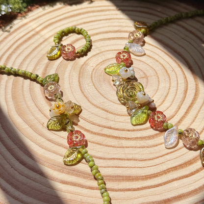 Jewelry set  with green and floral beads on a wooden surface with moss
