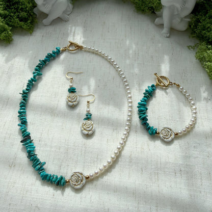 Handmade jewelry set featuring natural turquoise, freshwater pearls, and Czech glass rose beads, including a necklace, bracelet, and matching earrings displayed on a soft linen background.