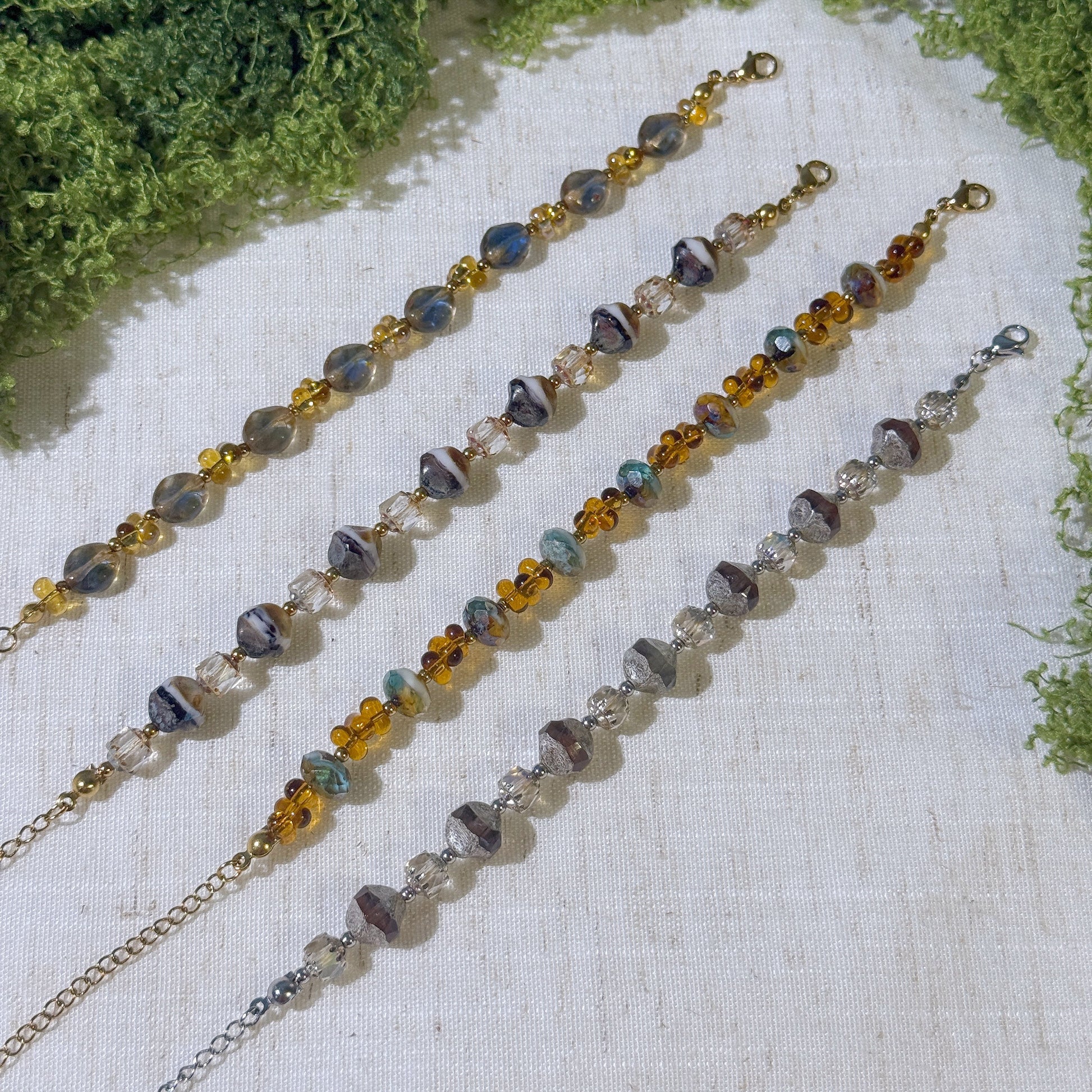 Four vintage-style bracelets with gold and silver tone.