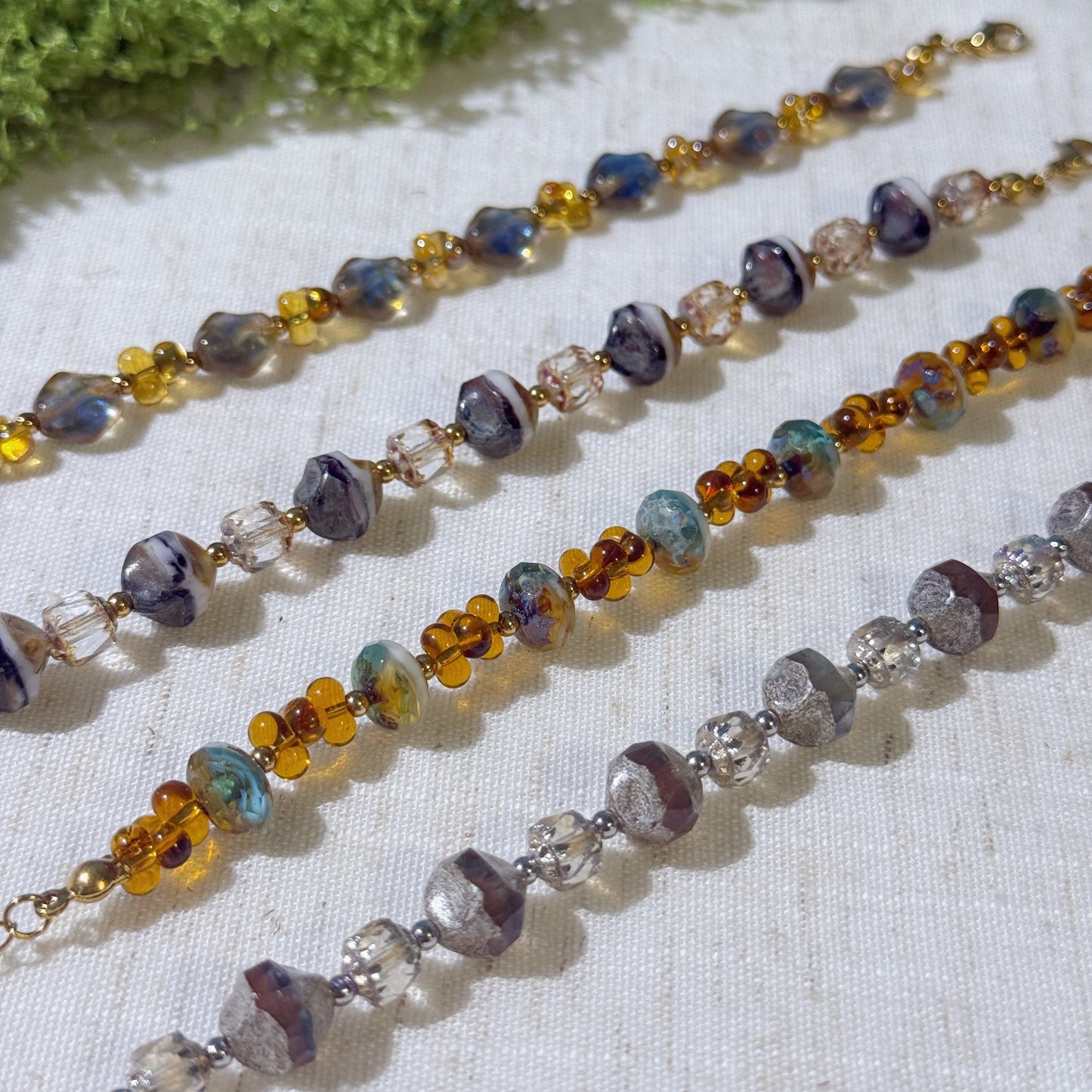 Four vintage-style bracelets with gold and silver tone.