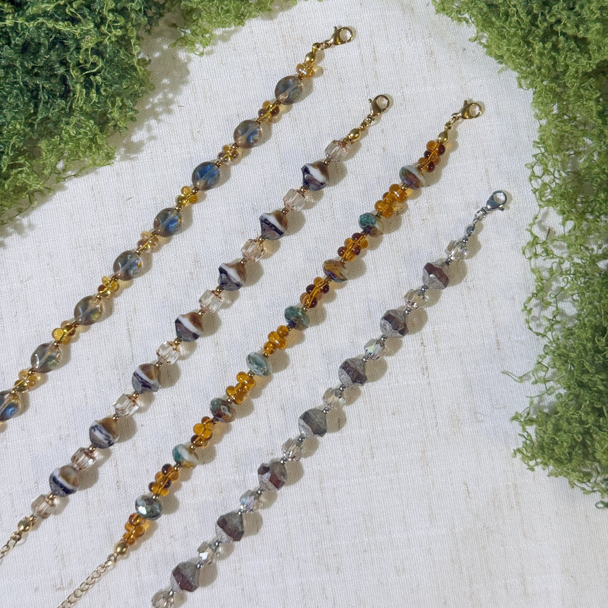 Four vintage-style bracelets with gold and silver tone.
