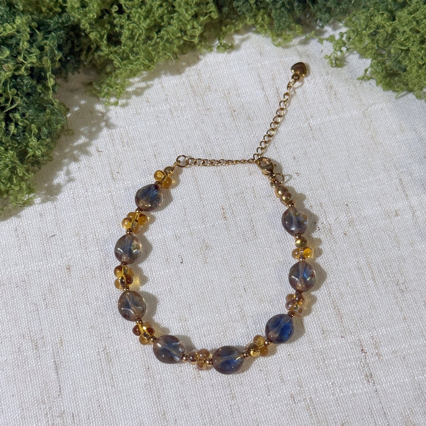Vintage-style bracelet with gold tone and smoky blue beads.