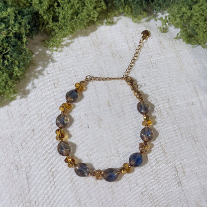 Vintage-style bracelet with gold tone and smoky blue beads.