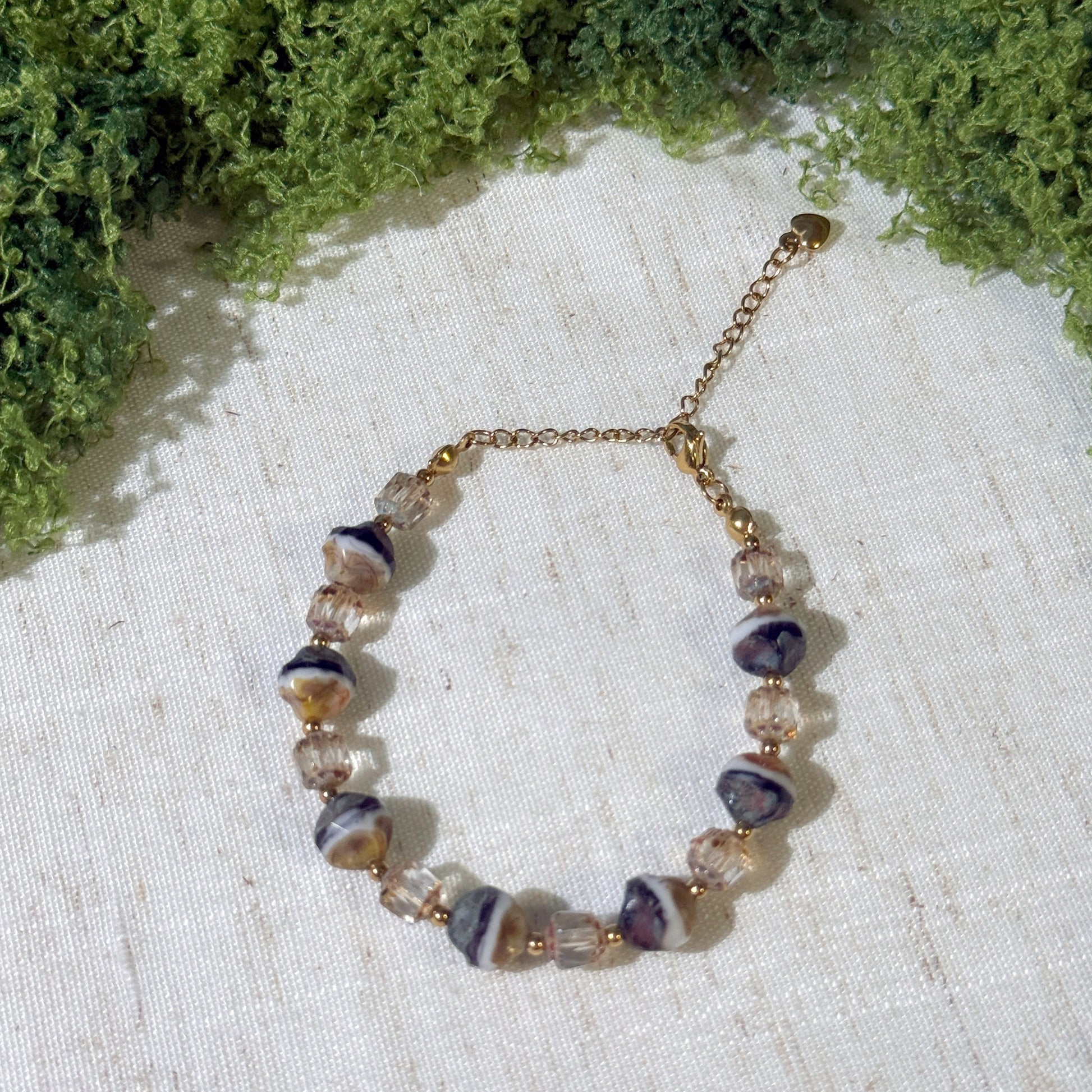 Vintage-style bracelet with gold tone and milky and black color beads.