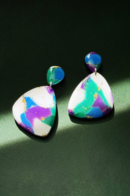 Handmade earrings with marble-like pattern in blue, green, purple, and white, accented with gold leaf, evoking the colors of the aurora in the night sky.