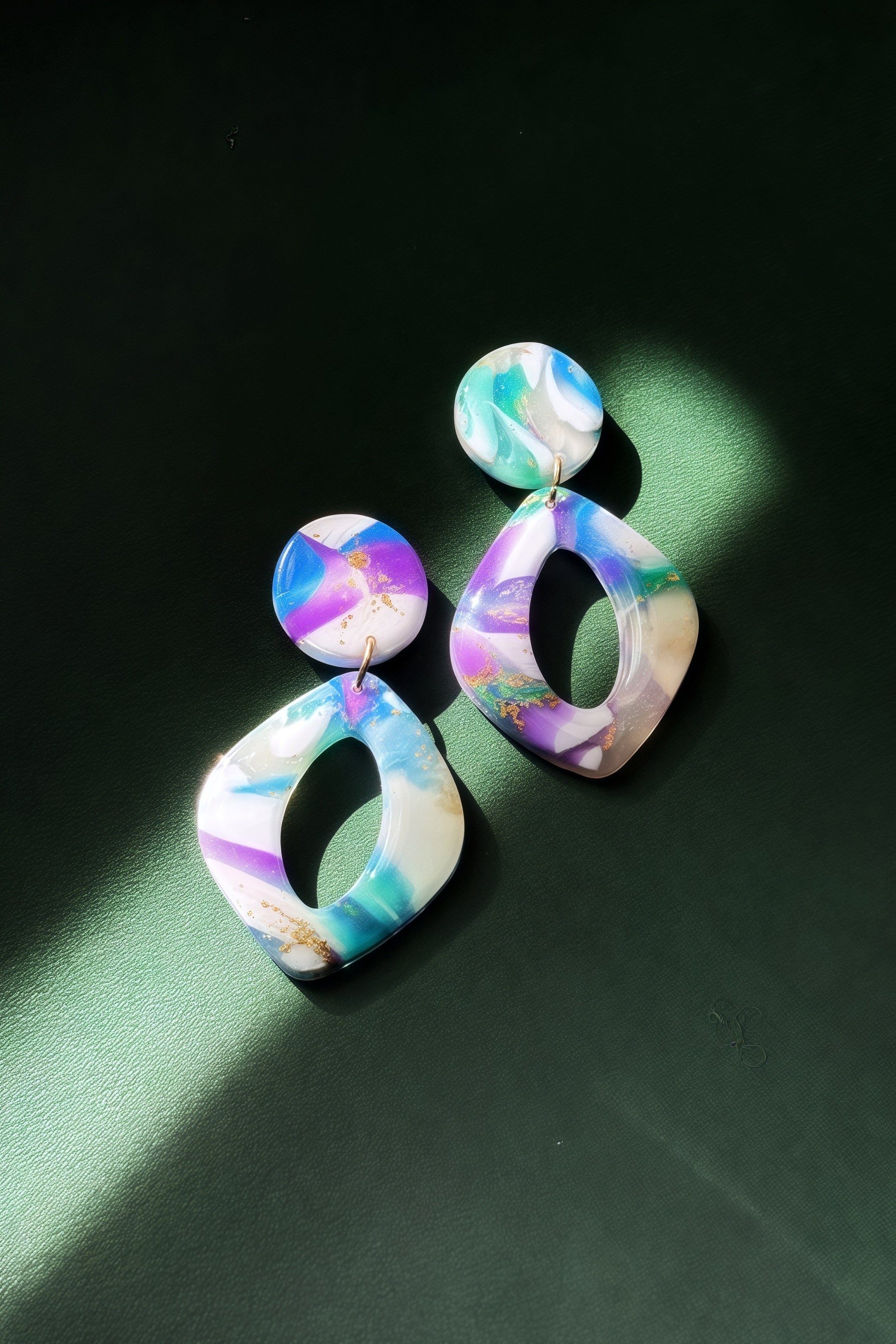 Handmade earrings with marble-like pattern in blue, green, purple, and white, accented with gold leaf, evoking the colors of the aurora in the night sky.