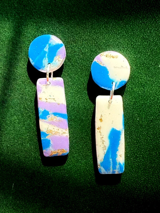 Pair of colorful marbled earrings on a green background
